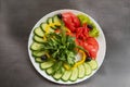 Assorted fresh vegetables on a plate .Dish of cucumbers, paprika, tomato and basil with parsley Royalty Free Stock Photo