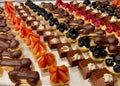 Assorted fruit and chocolate cakes and pastry in rows on silver tray. Close up. Royalty Free Stock Photo