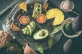 Assorted fruits on a plate. Avocados, blood oranges, kiwis, pineapple and strawberries