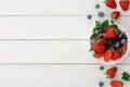 Mixed berries in glass bowls on white wooden table top view Royalty Free Stock Photo