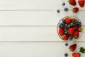 Mixed berries in glass bowls on white wooden table top view Royalty Free Stock Photo