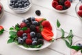 Mixed berries in glass bowls on white wooden table Royalty Free Stock Photo