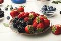 Mixed berries in glass bowls on white wooden table Royalty Free Stock Photo