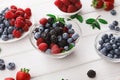 Mixed berries in glass bowls on white wooden table Royalty Free Stock Photo
