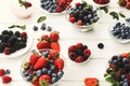 Mixed berries in glass bowls on white wooden table Royalty Free Stock Photo