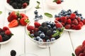 Mixed berries in glass bowls on white wooden table Royalty Free Stock Photo