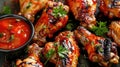 Assorted glazed barbecued chicken wings on a plate with sauces