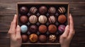 Assorted Gourmet Chocolates in a Gift Box Held in Hands. Royalty Free Stock Photo