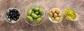 Assorted green and black olives in a bowl on a dark rustic background, border. View from above Royalty Free Stock Photo