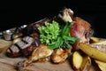 Assorted grilled meat. Knuckle, steaks, chicken duck, potatoes on a wooden board. Royalty Free Stock Photo
