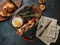 Assorted grilled meat, vegetables and spices, a kitchen table for serving meat, with napkins spread out and knives. Royalty Free Stock Photo