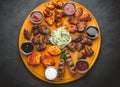 Assorted grilled meats and sauces on a wooden table