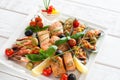 Assorted grilled seafood on white plate with sauce