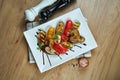 Assorted grilled vegetables - mushrooms, zucchini, peppers in a ceramic plate on a wooden background. Vegetarian warm salad. Royalty Free Stock Photo
