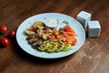 Assorted grilled vegetables - mushrooms, zucchini, peppers, corn in a ceramic plate on a wooden background. Vegetarian warm salad Royalty Free Stock Photo