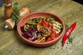 Assorted grilled vegetables - mushrooms, zucchini, peppers, corn in a ceramic plate on a wooden background. Vegetarian warm salad Royalty Free Stock Photo