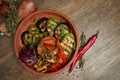 Assorted grilled vegetables - mushrooms, zucchini, peppers, corn in a ceramic plate on a wooden background. Vegetarian warm salad Royalty Free Stock Photo