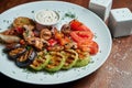 Assorted grilled vegetables - mushrooms, zucchini, peppers, corn in a ceramic plate on a wooden background. Vegetarian warm salad Royalty Free Stock Photo