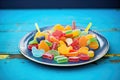 assorted gummy fruit slices on a blue plate