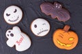 Assorted Halloween cookies on black slate.