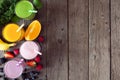Side border of assorted healthy smoothies against a rustic wood background with copy space Royalty Free Stock Photo