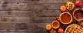 Assorted homemade autumn pies. Pumpkin, apple and pecan. Corner border on a rustic wood banner background.