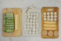 Assorted homemade semi-finished products on wooden boards. Frozen cutlets, dumplings, cabbage rolls and pancakes. Royalty Free Stock Photo