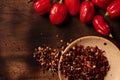 Assorted hot chilli pepper and crushed peppers on wooden surface with space for text Royalty Free Stock Photo