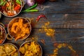 Assorted indian food set on wooden background. Dishes and appetisers of indeed cuisine, rice, lentils, paneer, samosa, spices. Royalty Free Stock Photo