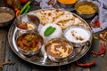 Assorted indian food set on wooden background. Dishes and appetisers of indeed cuisine, rice, lentils, paneer, samosa, spices.