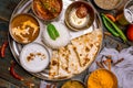 Assorted indian food set on wooden background. Dishes and appetisers of indeed cuisine, rice, lentils, paneer, samosa, spices, mas