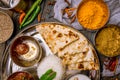 Assorted indian food set on wooden background. Dishes and appetisers of indeed cuisine, rice, lentils, paneer, samosa, spices, mas