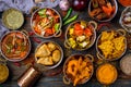 Assorted indian food set on wooden background. Dishes and appetisers of indeed cuisine, rice, lentils, paneer, samosa, spices, mas Royalty Free Stock Photo