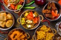 Assorted indian food set on wooden background. Dishes and appetisers of indeed cuisine, rice, lentils, paneer, samosa, spices, mas