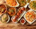 Assorted indian foods sabudana kichidi,chicken lollipop,chicken masala and schezwan fried rice on wooden background. Dishes and Royalty Free Stock Photo