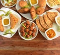 Assorted Indian Tea time snacks in group includes Spicy onion fritters, bread pakora,samosa, kachori and aloo paratha on wooden Royalty Free Stock Photo