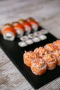 Assorted japanese sushi rolls on black background