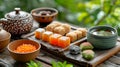 Assorted Japanese sweets wagashi on a wooden platter complemented by green tea against a natural backdrop. Concept of