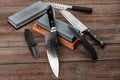 Assorted knives and sharpening stones on a rustic wooden table