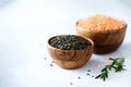 Assorted lentils. Marble, red and black raw organic lentils in wooden bowls with rosemary on grey concrete background