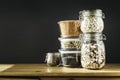 Assorted lentils. Marble, red and black raw organic lentils in wooden bowls with rosemary on grey concrete background. Copy space