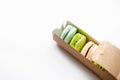 Assorted macaroons in craft paper box flat lay.white table background. top view Copyspace horizontal