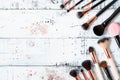 Assorted Makeup Brushes Arranged on a Distressed Wooden Surface With Paint Splatters Royalty Free Stock Photo