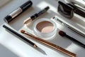 Assorted makeup brushes and cosmetics on white surface in sunlight Royalty Free Stock Photo