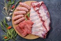 Assorted meat. Arrange the raw pork ribs, minced meat, sausages, and carbonate on a round cutting board. Seasonings for cooking Royalty Free Stock Photo