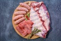 Assorted meat. Arrange the raw pork ribs, minced meat, sausages, and carbonate on a round cutting board. Seasonings for cooking Royalty Free Stock Photo