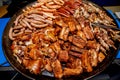 Assorted meat. Grilled sausages, ribs, shank in a large skillet Royalty Free Stock Photo