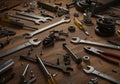 Assorted mechanical tools and gears scattered on wooden workbench surface Royalty Free Stock Photo