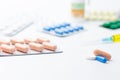 Assorted medical drugs and syringe on white background