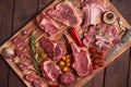 Assorted minced meat ingredients - rack of calf, ribeye, rack of lamb, with garlic, onions, red and yellow tomatoes, red pepper